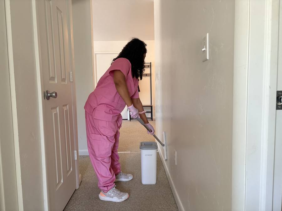 Cleaner wiping down hallway walls and baseboards in a Durango home
